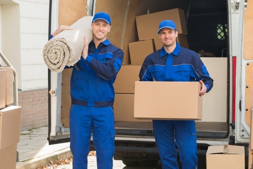 Professional movers handling flat removals in Stratford outside an apartment building