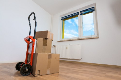 Movers carrying belongings through a Stratford flat hallway